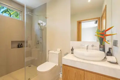 a bathroom with a sink and a toilet and a shower at The Sandstone Villa at Trichada Breeze in Laguna Phuket