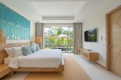 a bedroom with a large bed and a television at The Sandstone Villa at Trichada Breeze in Laguna Phuket