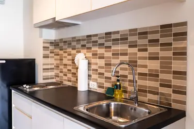 a kitchen with a sink and a tiled wall at Patong hillside Condo with pool, bar, parking in Patong Beach