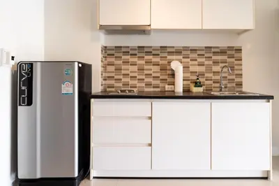 a kitchen with a refrigerator and white cabinets at Patong hillside Condo with pool, bar, parking in Patong Beach