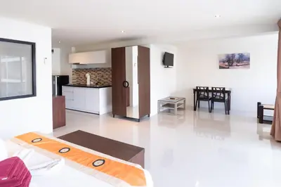 a kitchen and a living room with a surfboard on the floor at Patong hillside Condo with pool, bar, parking in Patong Beach