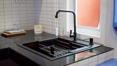 a kitchen counter with a sink with a faucet at Tiny house bangtao in Ban Thalat Choeng Thale