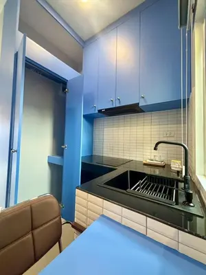 a kitchen with a sink and blue cabinets at Tiny house bangtao in Ban Thalat Choeng Thale