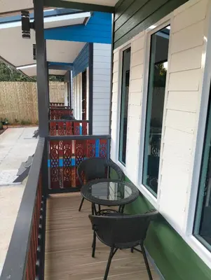 a patio with two chairs and a table on a porch at The Nap Koh Yao Yai in Ban Nai Wat