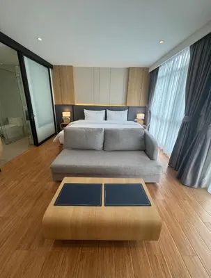 a bedroom with a large bed and a table at Wyndham apartment Naithon in Nai Thon Beach