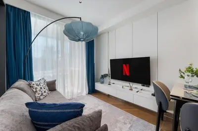 a living room with a couch and a tv at Tinos 1BR Suite at Kora Beach Resort in Layan Beach