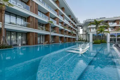 an empty swimming pool in a building with palm trees at Lamia 1BR Suite at Kora Beach Resort in Layan Beach