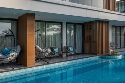 a resort with a swimming pool and chairs next to a building at Lamia 1BR Suite at Kora Beach Resort in Layan Beach