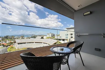 a balcony with a table and chairs and a view at Mida Grande Surin Private Suites in Ban Lum Fuang