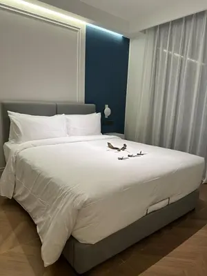 a large white bed with two birds on it at Kora Beach Resort Residence 2 bedroom by Ere in Layan Beach