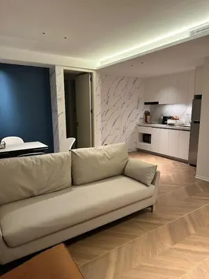 a living room with a couch and a kitchen at Kora Beach Resort Residence 2 bedroom by Ere in Layan Beach