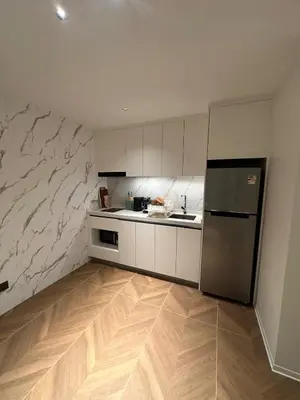 a kitchen with white cabinets and a stainless steel refrigerator at Kora Beach Resort Residence 2 bedroom by Ere in Layan Beach