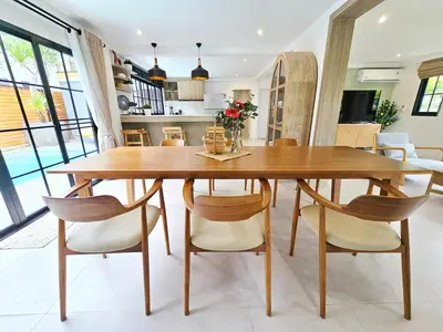 a dining room with a wooden table and chairs at Boutique pool villa in Soi Bell,Kamala in Kamala Beach