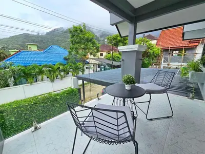 a patio with two chairs and a table on a balcony at Boutique pool villa in Soi Bell,Kamala in Kamala Beach