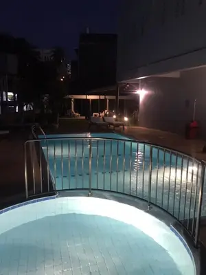a swimming pool at night with a railing at Karon Place in Ban Karon