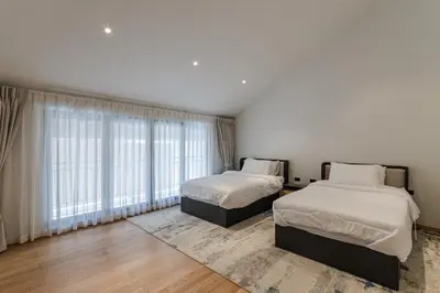 a bedroom with two beds and a large window at PRAIA Residence 5BR - Bangtao in Ban Pak Lak