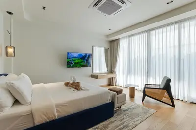 a bedroom with a bed with a teddy bear on it at PRAIA Residence 5BR - Bangtao in Ban Pak Lak