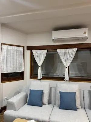 a living room with a couch with two blue pillows at KONE- 3BR Private Pool Villa Kathu near Patong in Ban Kathu