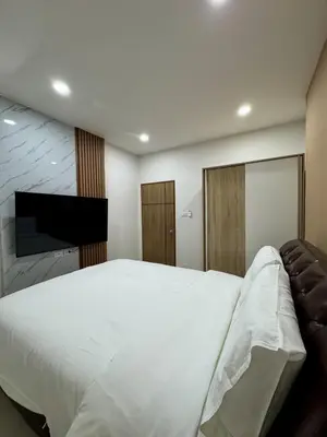 a bedroom with a large white bed and a flat screen tv at KONE- 3BR Private Pool Villa Kathu near Patong in Ban Kathu