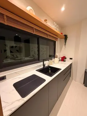 a kitchen with a sink and a window at Chareen Pool Villa in Ban Khlong Haeng