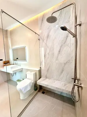 a bathroom with a shower with a toilet and a sink at Chareen Pool Villa in Ban Khlong Haeng