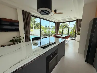 a kitchen with a glass counter top and a large window at Chareen Pool Villa in Ban Khlong Haeng