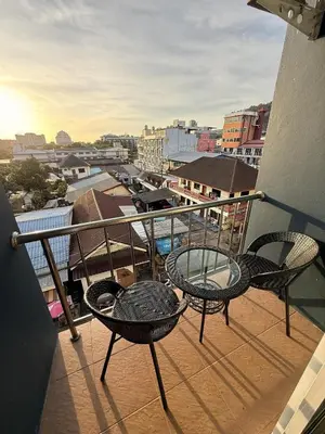 a balcony with two chairs and a table on a building at Nova Inn in Patong Beach