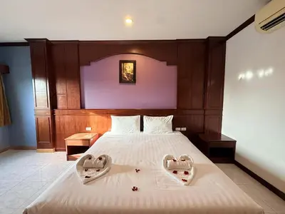 a bedroom with a large bed with two heart shaped towels at Nova Inn in Patong Beach