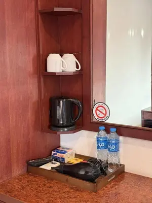 a kitchen counter with a coffee maker and bottles of water at Nova Inn in Patong Beach