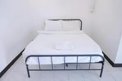 a white bed with a black frame and white sheets at GO INN Patong - โกอินน์ ป่าตอง in Patong Beach