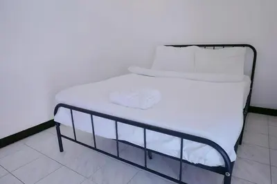 a bed with white sheets and white pillows on it at GO INN Patong - โกอินน์ ป่าตอง in Patong Beach