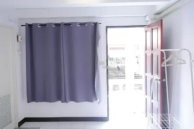 a bathroom with a blue shower curtain next to a window at GO INN Patong - โกอินน์ ป่าตอง in Patong Beach