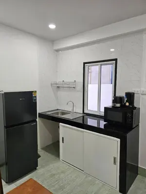 a kitchen with a black refrigerator and a sink at Large 1 Bedroom Apt Sleeps 4, Close to Beach - RM 2 in Ban Lum Fuang