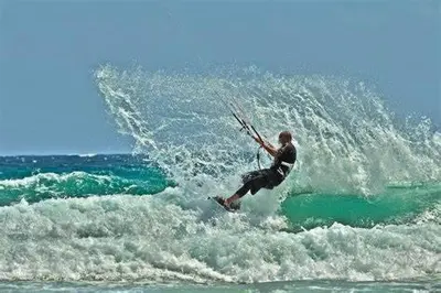a man riding a wave on a surfboard in the ocean at Large 1 Bedroom Apt Sleeps 4, Close to Beach - RM 2 in Ban Lum Fuang