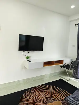 a living room with a tv on a white wall at Large 1 Bedroom Apt Sleeps 4, Close to Beach - RM 2 in Ban Lum Fuang