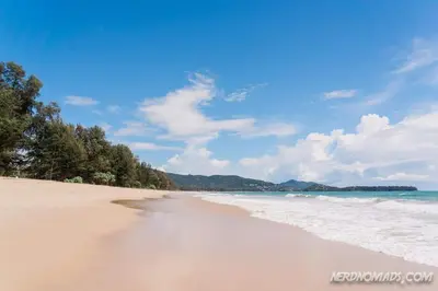 a sandy beach with trees and the ocean at Large 1 Bedroom Apt, Sleeps 4, close to beach - RM 4 in Ban Lum Fuang