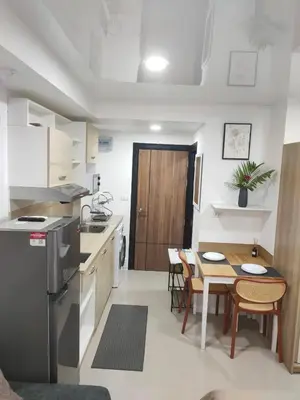 a kitchen and dining room with a table and a refrigerator at 777 Condo Phuket in Ban Mai Salae