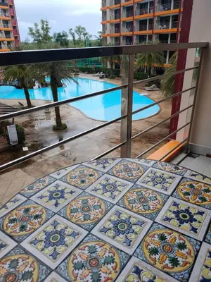 a balcony with a view of a pool on a building at 777 Condo Phuket in Ban Mai Salae