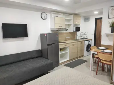 a living room with a couch and a kitchen at 777 Condo Phuket in Ban Mai Salae