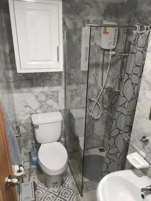a bathroom with a toilet and a shower and a sink at 777 Condo Phuket in Ban Mai Salae