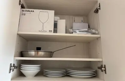 a cupboard with plates and a bowl and a box at Квартира в Legendary Bang Tao in Bang Tao Beach