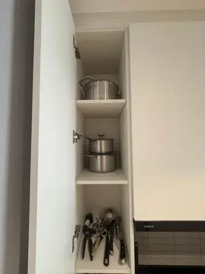 a cupboard filled with cooking utensils in a kitchen at Квартира в Legendary Bang Tao in Bang Tao Beach