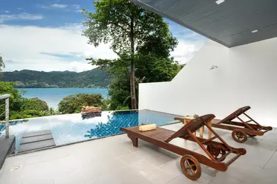 a view of a pool from a house with a wooden cart at Atika Villa 6 ocean view pool villa in Patong Beach