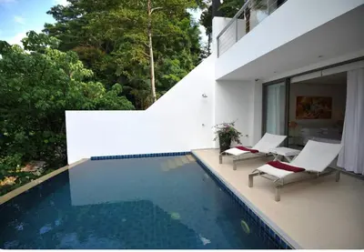 a swimming pool with two lounge chairs and a house at Atika Villa 6 ocean view pool villa in Patong Beach