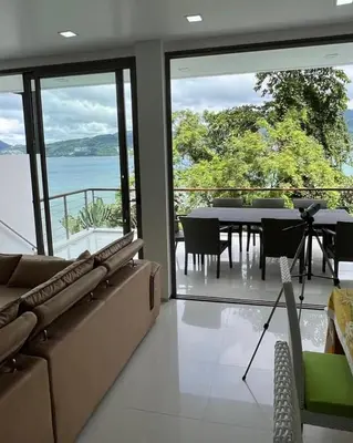 a living room with a couch and a dining table at Atika Villa 6 ocean view pool villa in Patong Beach