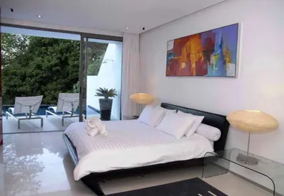 a bedroom with a bed with a glass table and two lamps at Atika Villa 6 ocean view pool villa in Patong Beach