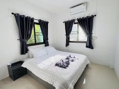a small bedroom with a bed with black curtains at SINTO Homestay Yao Noi in Ko Yao Noi