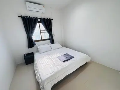 a small bedroom with a white bed with a window at SINTO Homestay Yao Noi in Ko Yao Noi