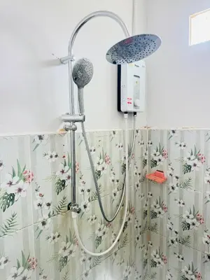 a shower in a bathroom with a floral shower curtain at SINTO Homestay Yao Noi in Ko Yao Noi