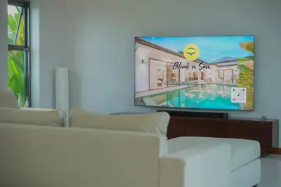 a living room with a white couch and a flat screen tv at Villa Tropicana - Luxury 4 Bedroom Villa in Rawai Beach